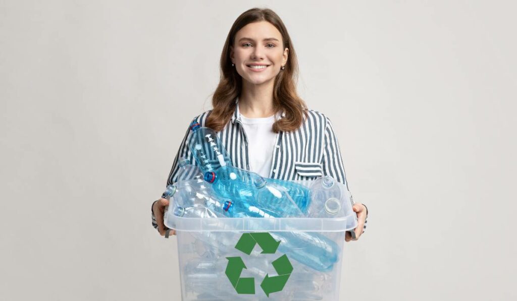 A woman holding a reusable recycling bin with plastic bottles in it. It's eco-friendly and unlike cardboard boxes, it can be used multiple times.