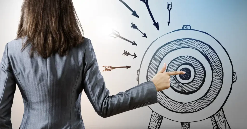 a woman in a business suit is pointing at a target with arrows