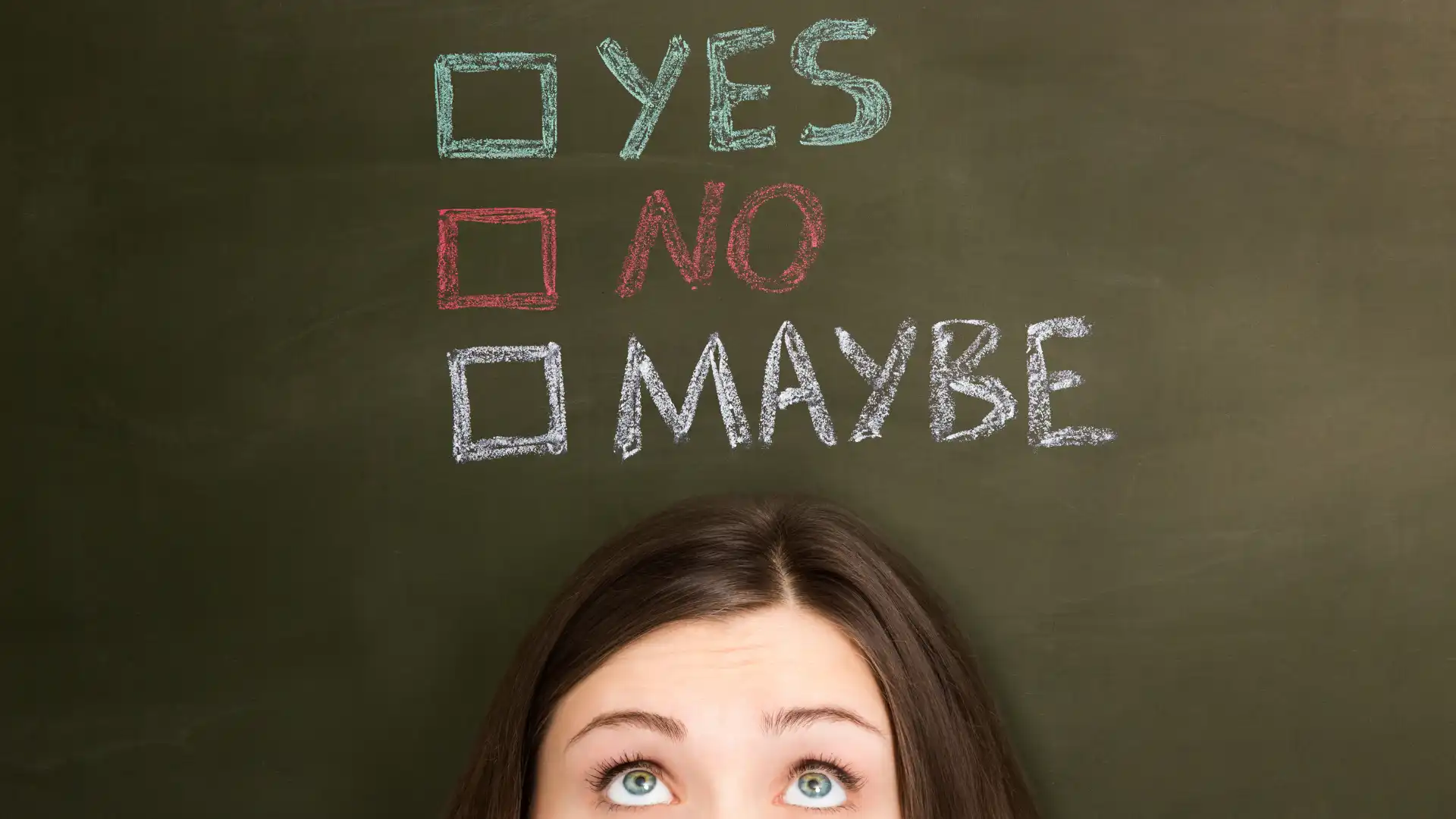 a woman is looking at yes, no and may be written on a black board