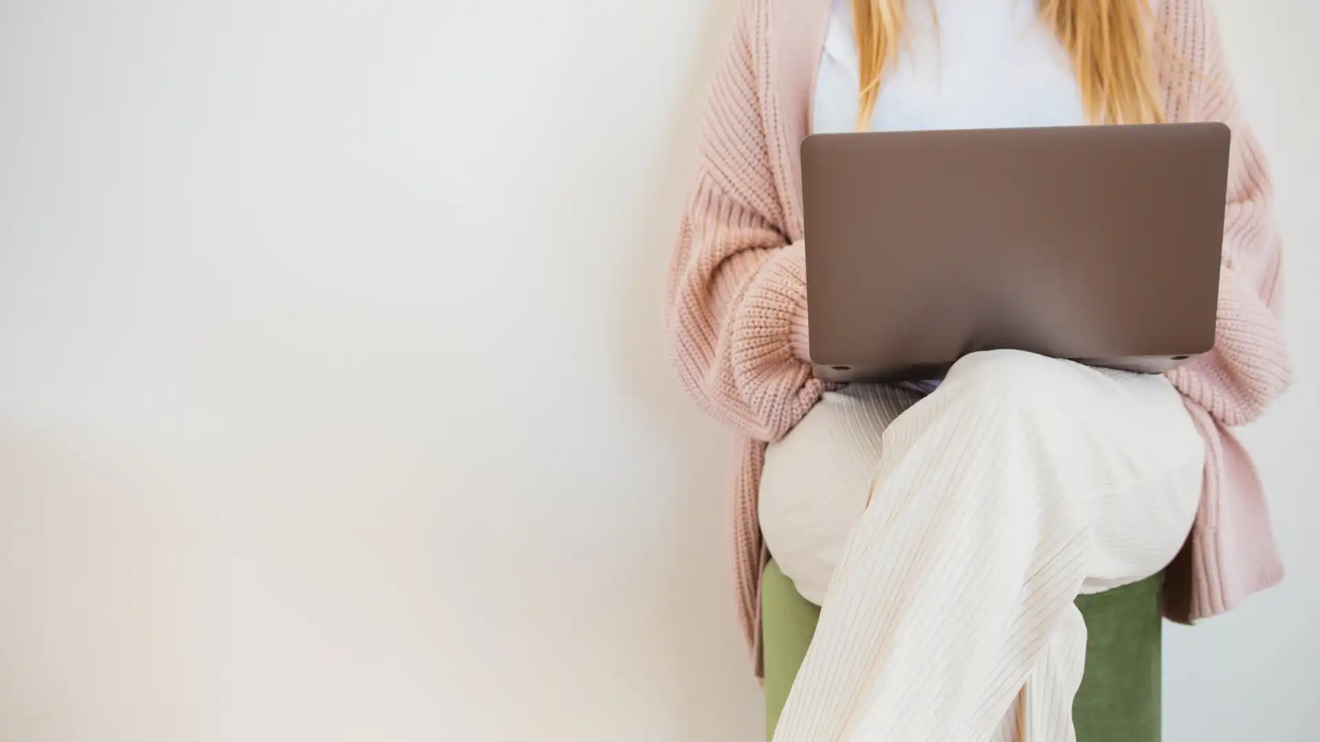 a woman sitting on a stool with a laptop earning full time income through her business